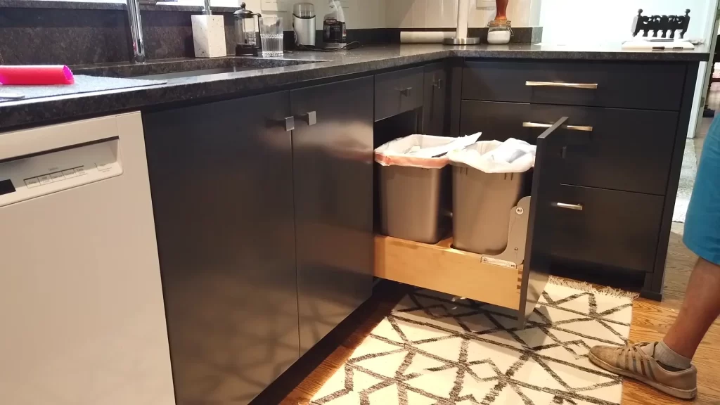 Poubelle coulissante installée dans un tiroir sous l'évier de cuisine